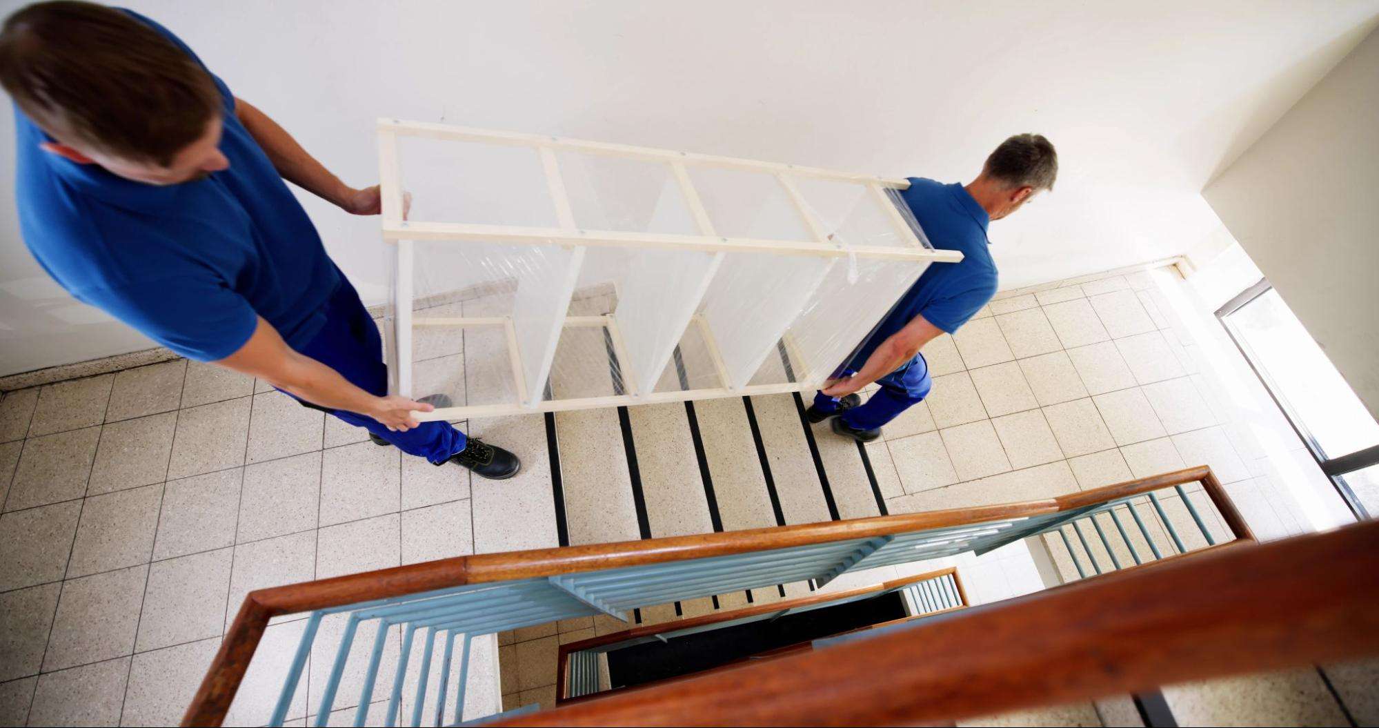 professional movers carrying a shelf down stairs