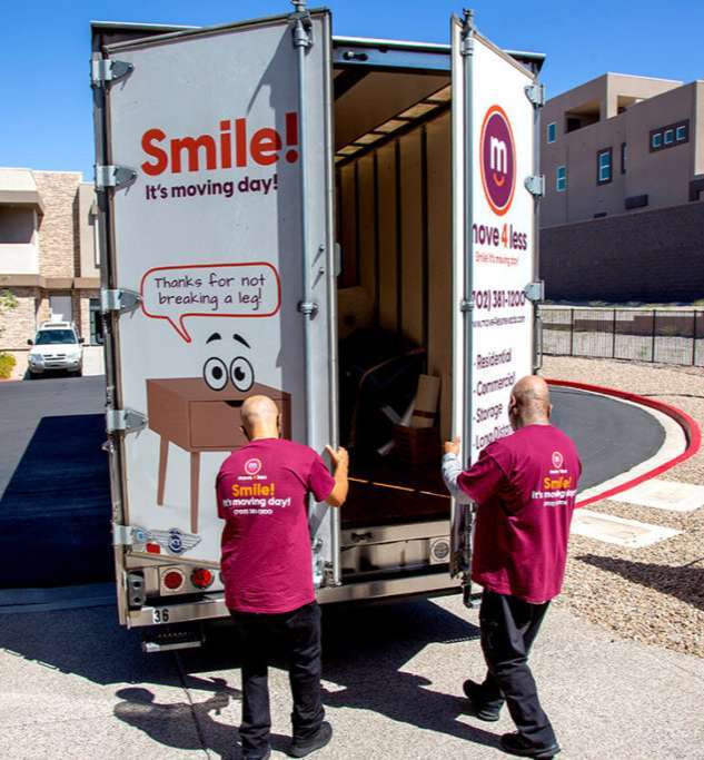 Laughing woman cuddling baby with plush toys next to Denver local movers Move 4 Less brown cardboard moving boxes stacked