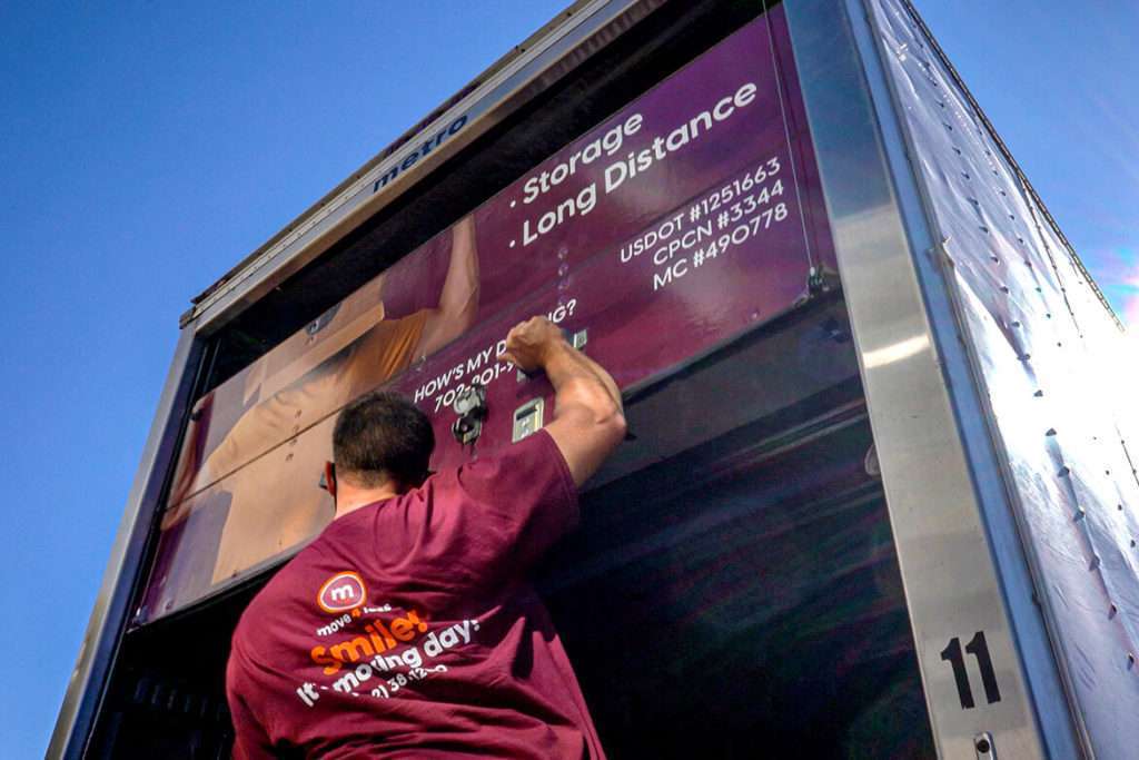 A professional mover closing the back of a truck