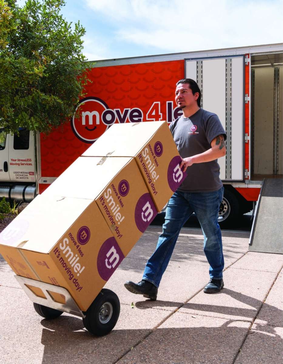 A professional mover hauling boxes into a Raleigh home
