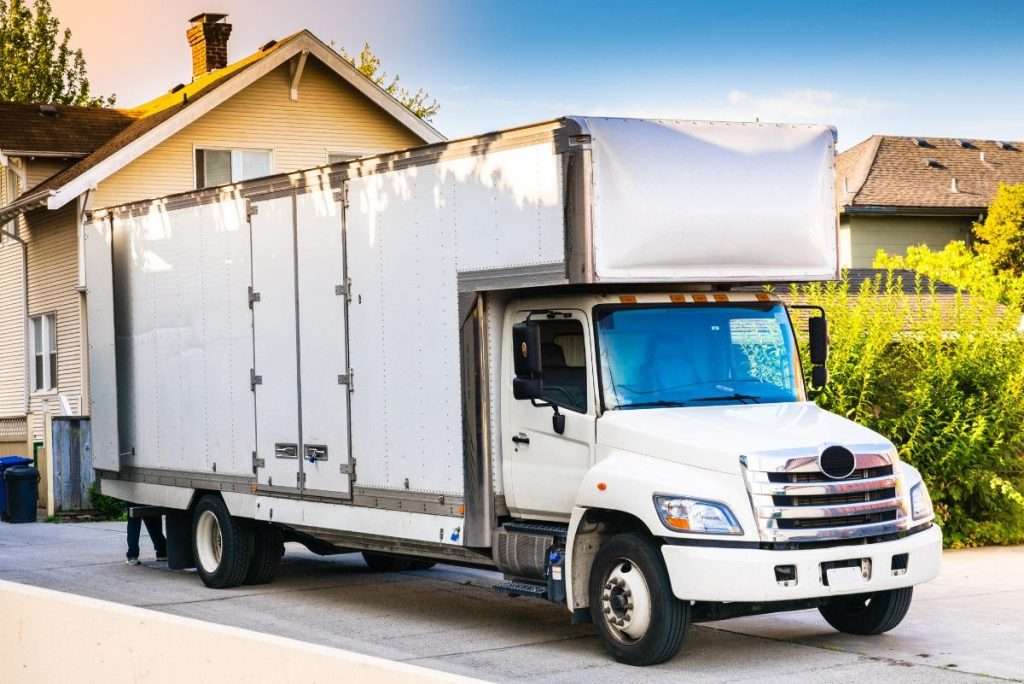 A white commercial moving truck parked outside of a customer’s home