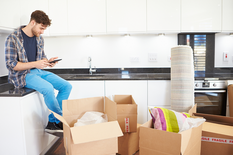 Man Sending Text Message Having Moved Into New Home